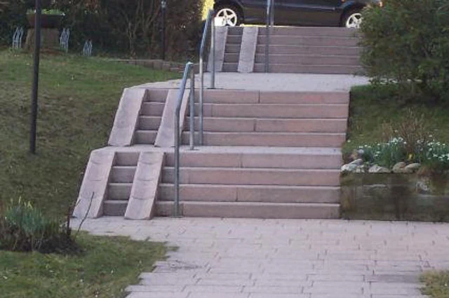 Treppenanlage mit Handlauf und seitlicher Schieberampe im Garten